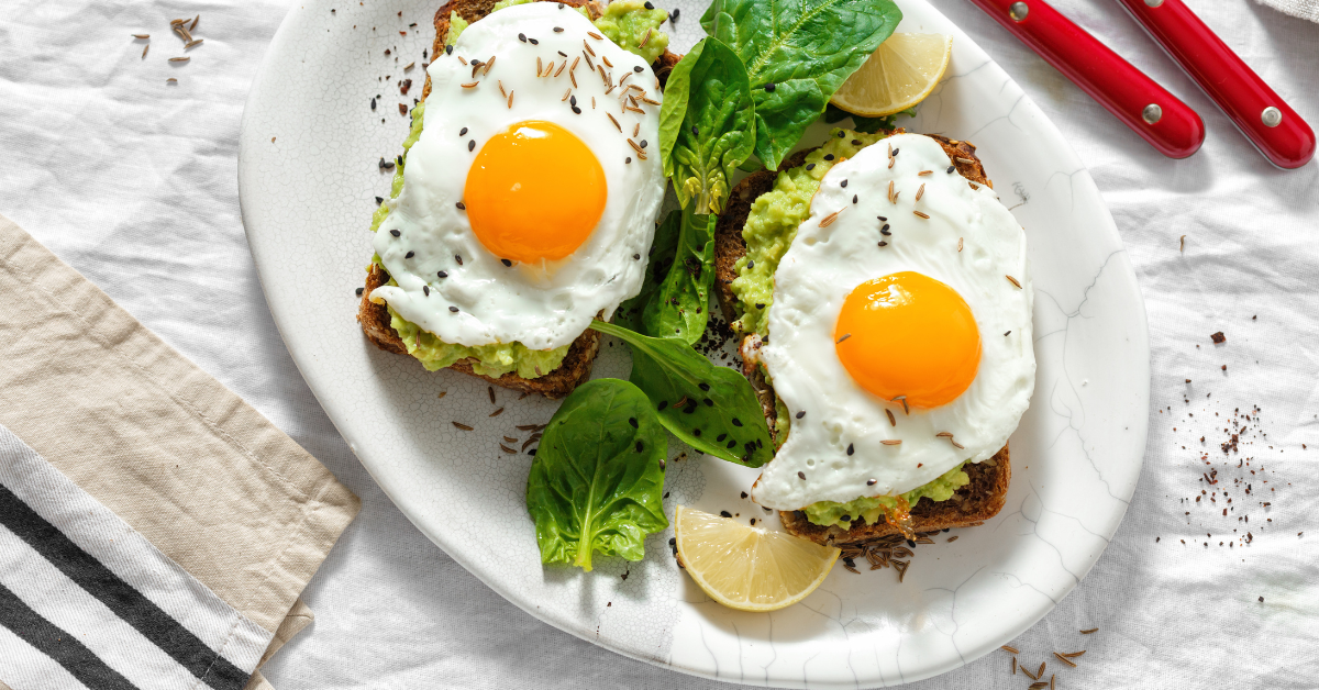 Healthy Breakfast with Eggs and Avocados Plate featuring sunny-side-up eggs and sliced avocados, garnished with fresh herbs, promoting a balanced diet.