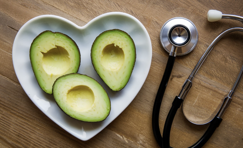 A heart-shaped plate holding avocado slices, with a stethoscope placed beside it.