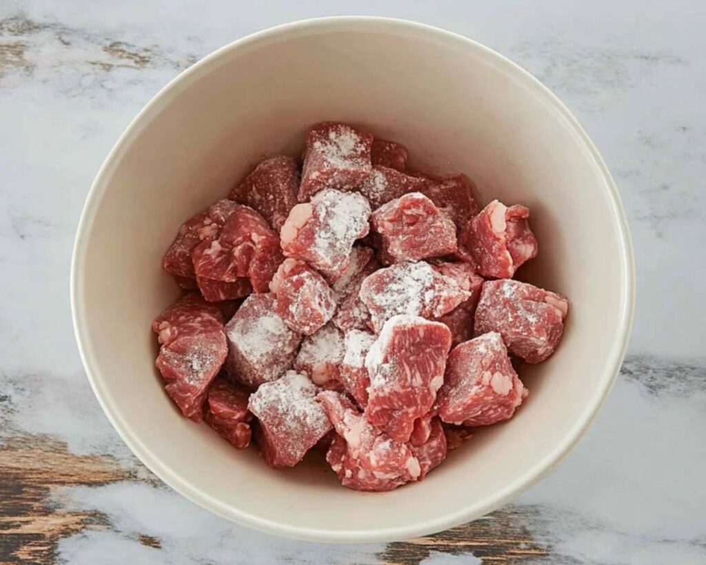 Step-3: Stew meat in a bowl coated with flour, salt, and pepper.