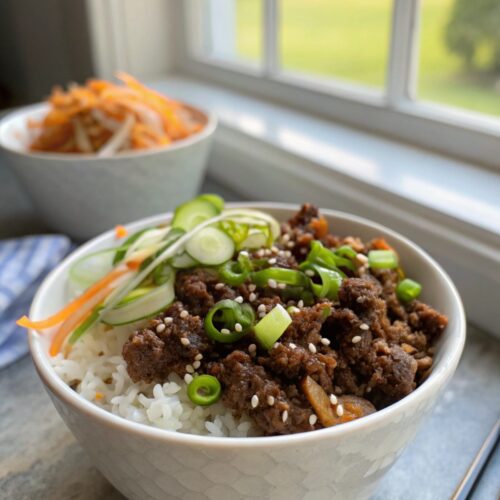 A delicious Korean Ground Beef Bowl served with rice and garnished with fresh toppings.