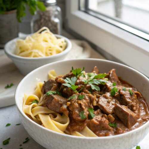 Close-up of creamy homemade beef stroganoff served in a white bowl.