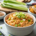 A delicious bowl of buffalo chicken dip, garnished and ready to serve.