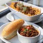 Cheesesteak Sloppy Joes served on a white plate, topped with fresh greenery.