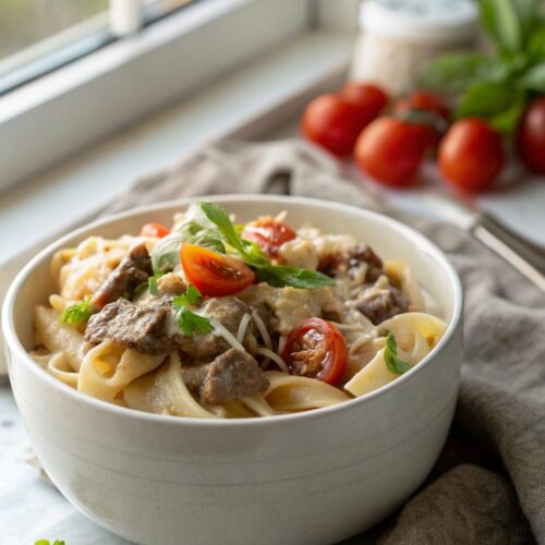Finished creamy beef pasta served in a bowl with garnish