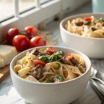 Hearty serving of creamy high protein beef pasta on a white plate