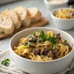 Delicious ground beef stroganoff served in a bowl with garnish.