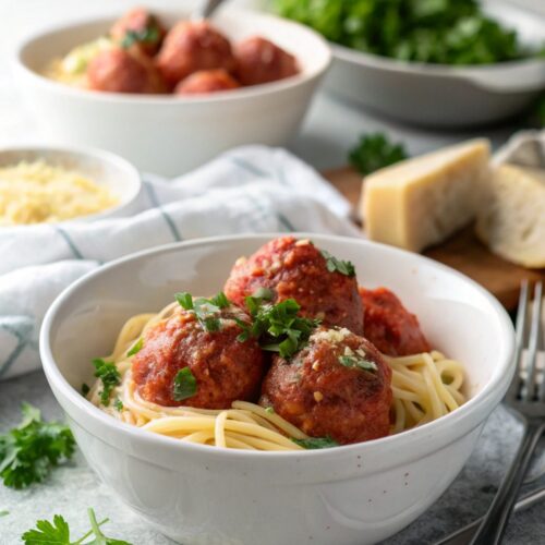 A plate of homemade Italian meatballs garnished with fresh herbs.