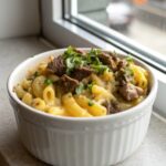Close-up of Philly Cheesesteak Mac and Cheese garnished and ready to serve.