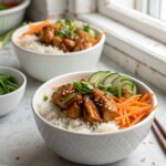 A mouth-watering photo of sticky chicken rice bowls served in a white bowl.
