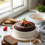 A luscious slice of vegan chocolate cake on a white plate.