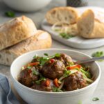 A plate of delicious Mongolian Beef Meatballs garnished with sesame seeds and green onions.