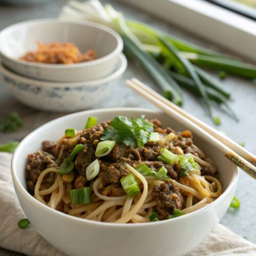 Mouthwatering Mongolian ground beef noodles served with garnish.