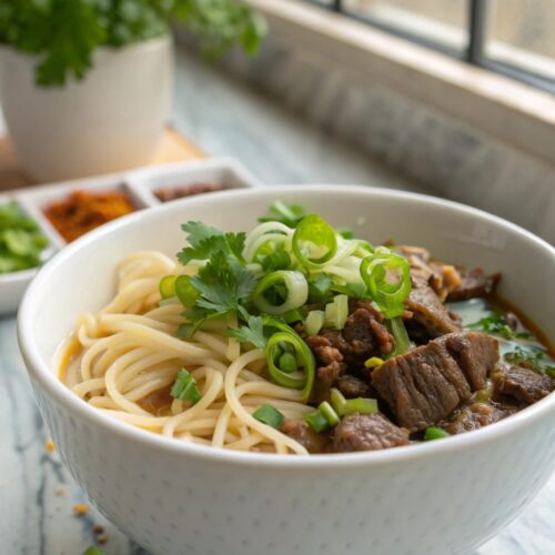Delicious Quick Beef Noodles served in a white bowl with fresh garnish